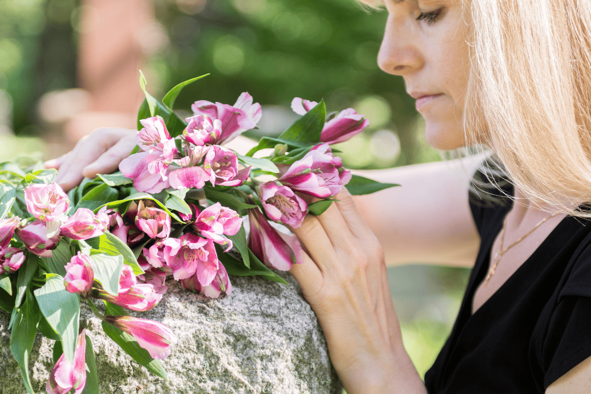 Woman at grave with flowers