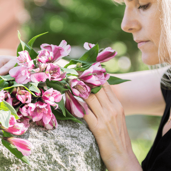 Woman at grave with flowers