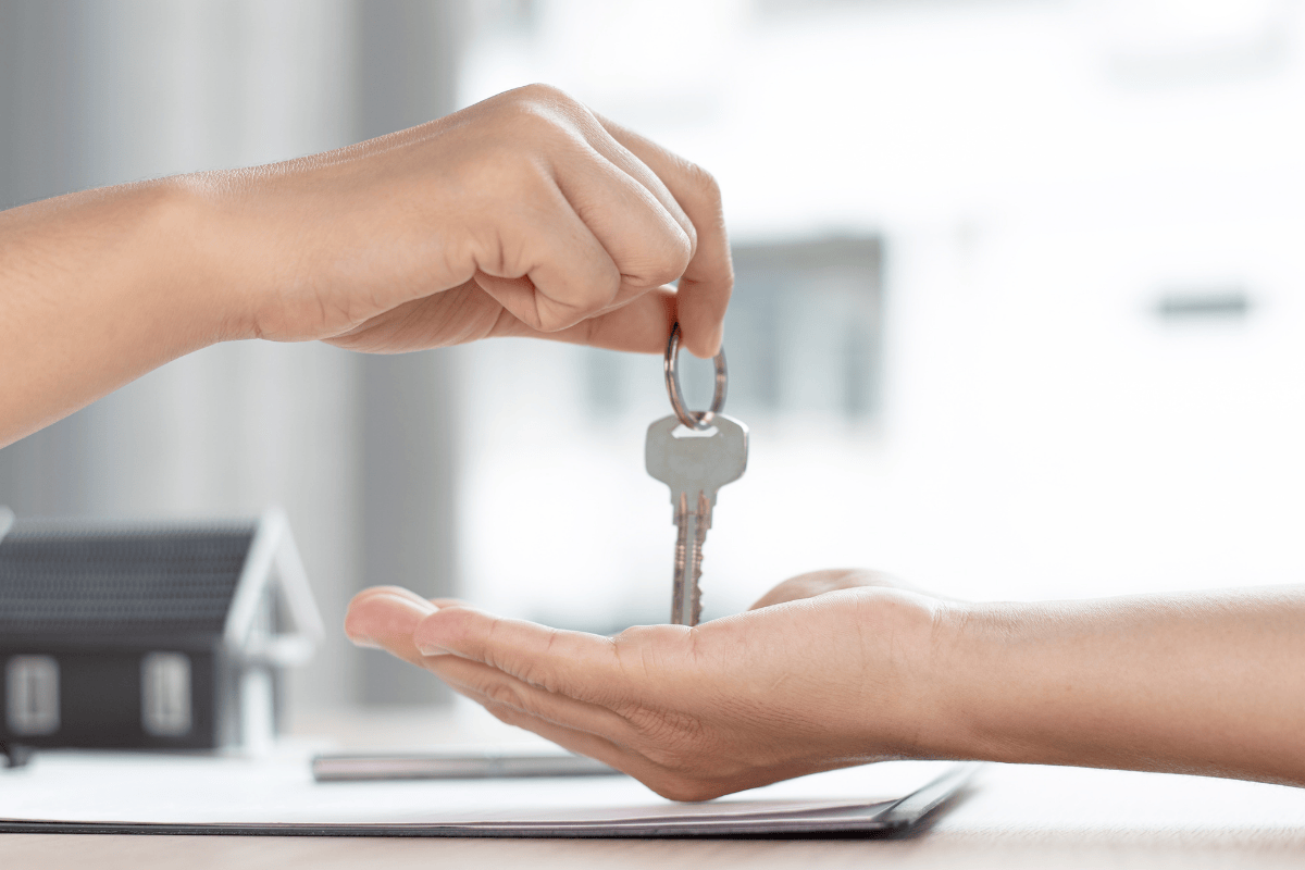 Two hands with new homeowner receiving keys to home