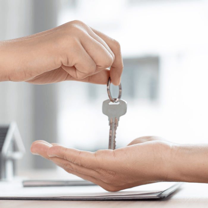 Two hands with new homeowner receiving keys to home