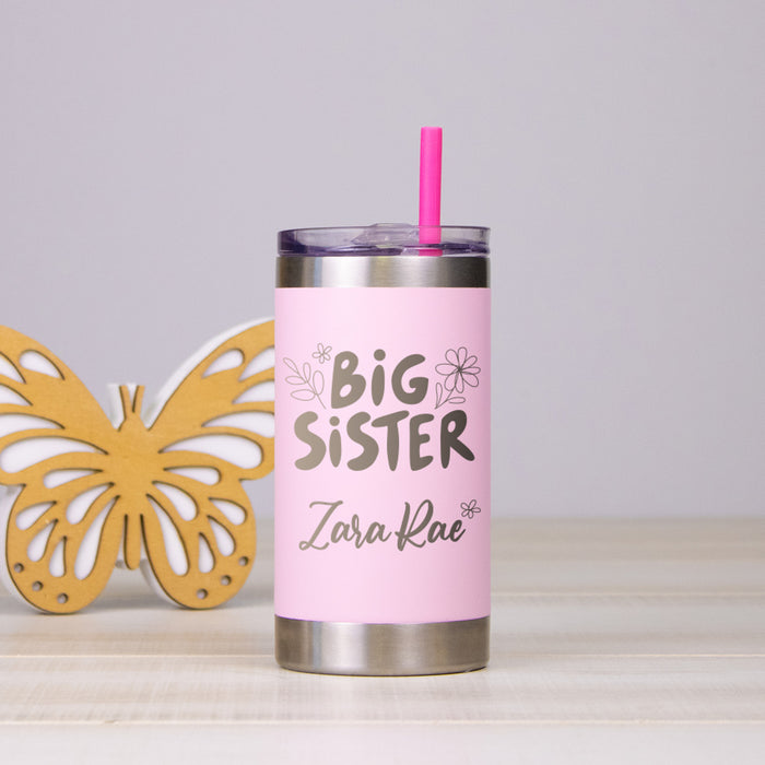 Pink tumbler with 'Big Sister' personalization and soft straw, next to a yellow butterfly decoration on a light gray background