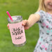 Child holding a pink 'Big Sister' tumbler engraved with her name with a straw standing outside in grass