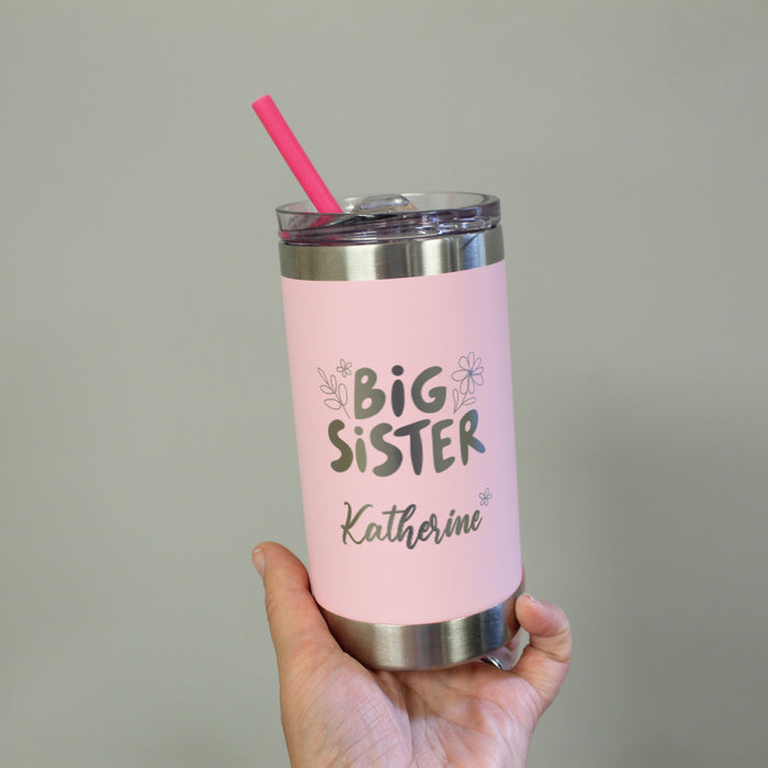 Pink tumbler with 'Big Sister' text held by a hand against a neutral background