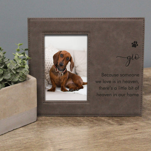 gray leather photo frame with a dog picture and text on a wooden surface.