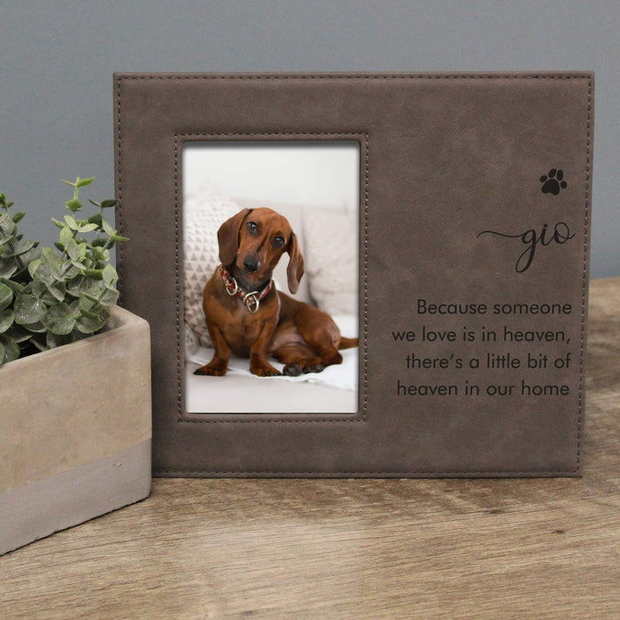 gray leather photo frame with a dog picture and text on a wooden surface.