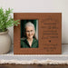 Personalized photo frame with engraved text and a portrait of an elderly woman, placed on a surface with a plant and a table runner.