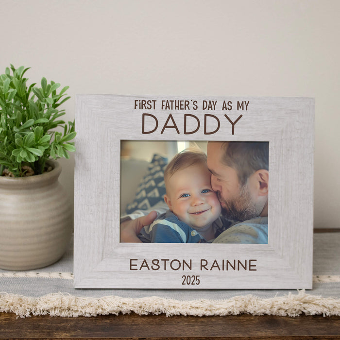 Personalized photo frame for Father's Day with a photo of a man and child, placed on a wooden surface with a plant in the background.