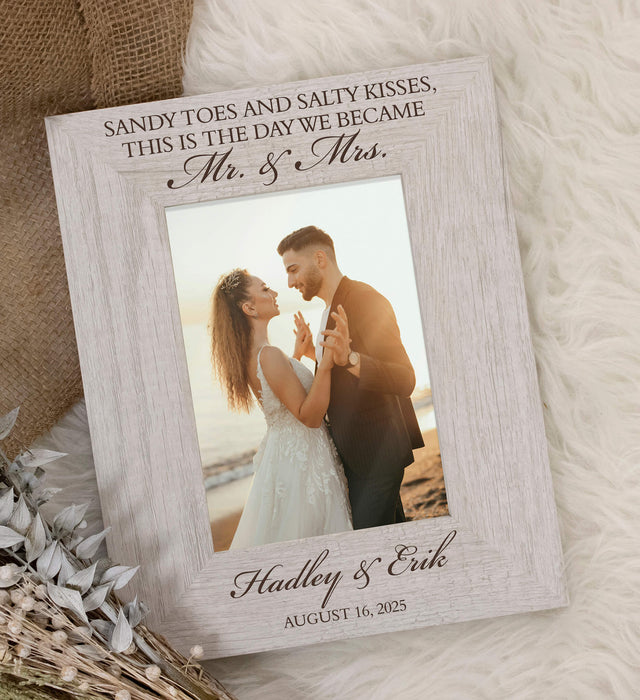 Personalized photo frame with a couple on a beach and text 'Sandy Toes and Salty Kisses, This is the Day We Became Mr. & Mrs.'