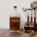 Personalized whiskey bottle with glass and bar tools on a wooden surface