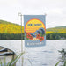 summer garden flag with a 'Don't worry, beach happy' design placed in front of a lake