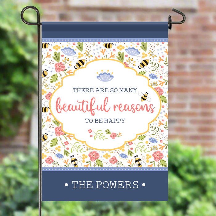 Decorative garden flag with floral design and motivational quote on a stand outdoors.