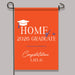 Orange garden flag with 'Home of a 2026 Graduate' text and graduation cap design on a gray background.