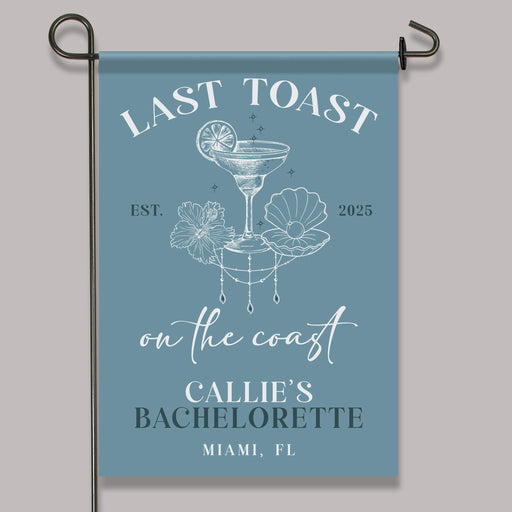 Garden flag with 'Last Toast on the Coast' design and text on a blue background