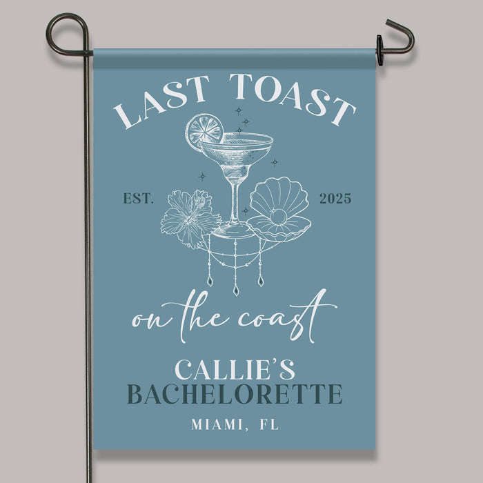 Garden flag with 'Last Toast on the Coast' design and text on a blue background