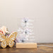 Decorative LED light with floral design and text on a wooden base