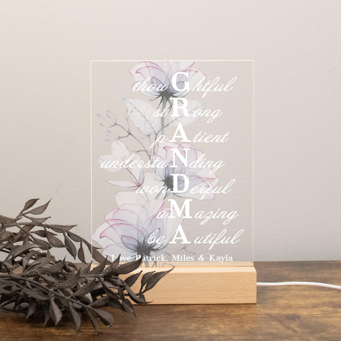 Decorative LED light with floral design and text on a wooden base.