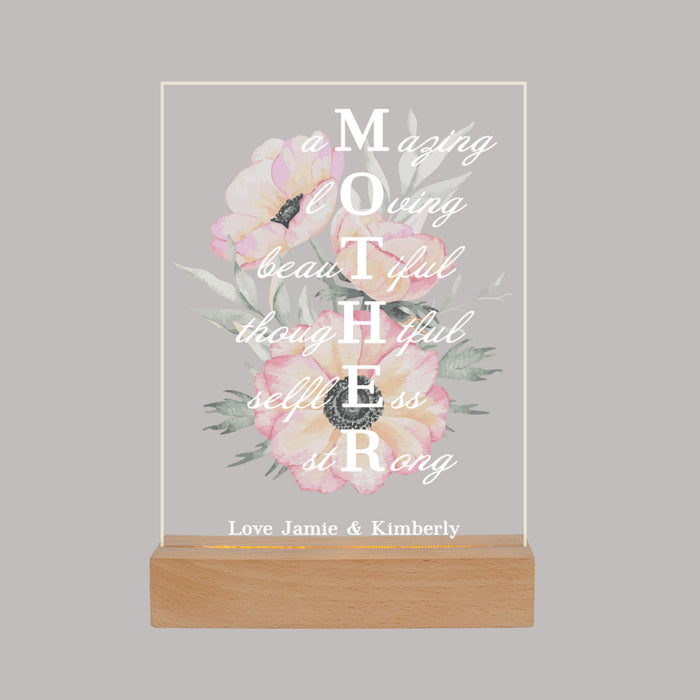 LED light with "MOTHER" printed vertically  and flowers in the background