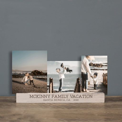 Three photo prints on a wooden stand with 'Mckinny Family Vacation' text against a gray wall.