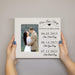 Personalized photo frame with engraved couple's name and special dates, held by hands against a neutral background.