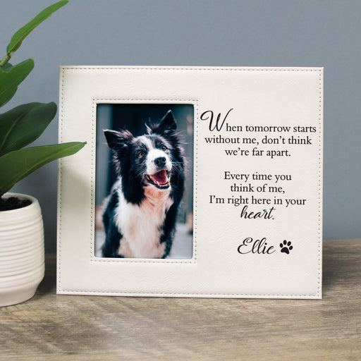 White photo frame with a dog picture and text on a wooden surface.