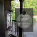 Memorial solar wind chime with engraved text on a blurred outdoor background