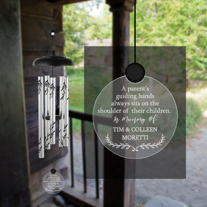 Parents memorial solar wind chime with a personalized message on a blurred outdoor background
