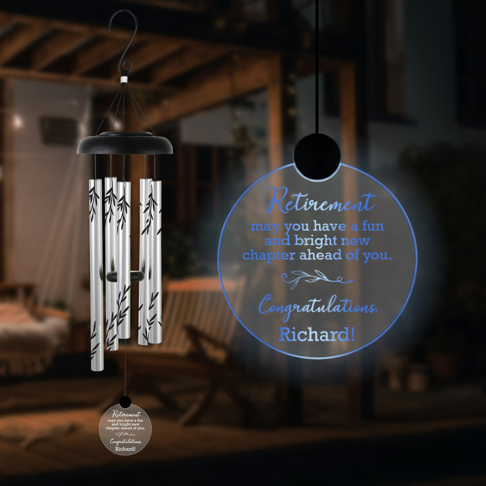 Wind chime with personalized retirement message on a blurred background