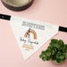 Baby announcement dog bandana with text and rainbow design on a pink background with a plant.