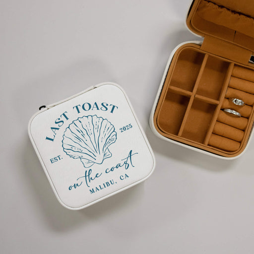 Jewelry case with 'Last Toast on the Coast' design and open to reveal rings.