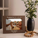 Brown photo frame engraved for a grandma to be on a night stand styled with a plant vase and beads