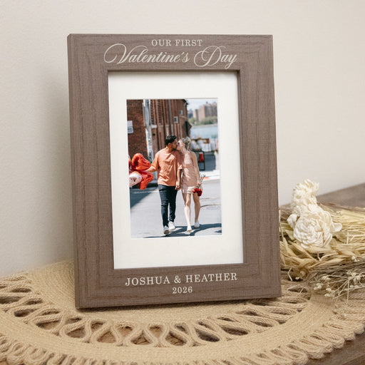 brown 5x7 picture frame that also holds 4x6 and is engraved with "Our First Valentine's Day", the couples names and the year