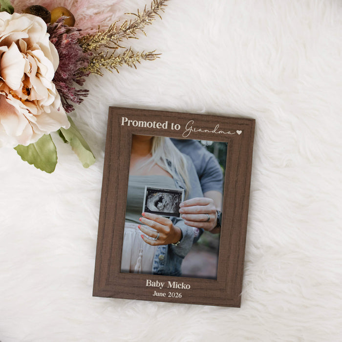 Brown vertical picture frame engraved with "Promoted to Grandma" on the top and personalization on the bottom