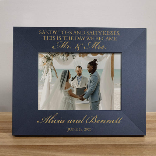 black photo frame with engraved text and a wedding photo of two people holding hands.