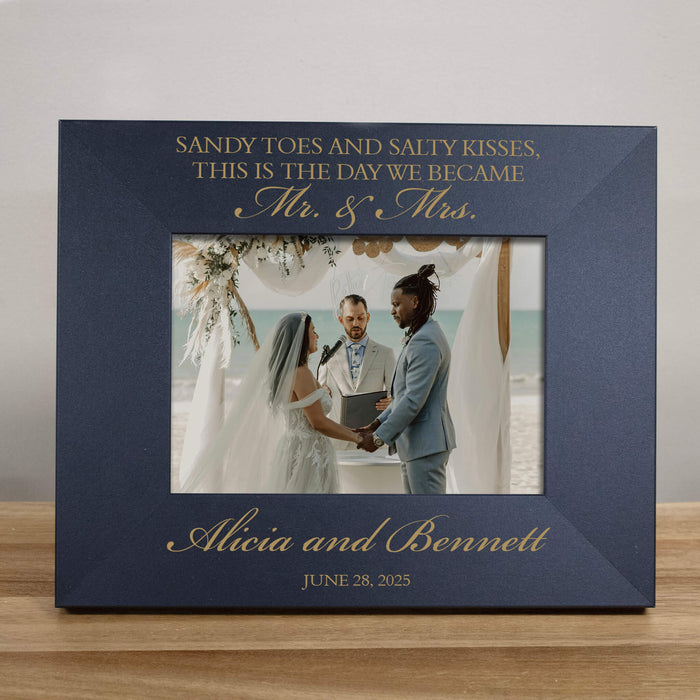 black photo frame with engraved text and a wedding photo of two people holding hands.