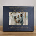 black photo frame with engraved text and a wedding photo of two people holding hands.