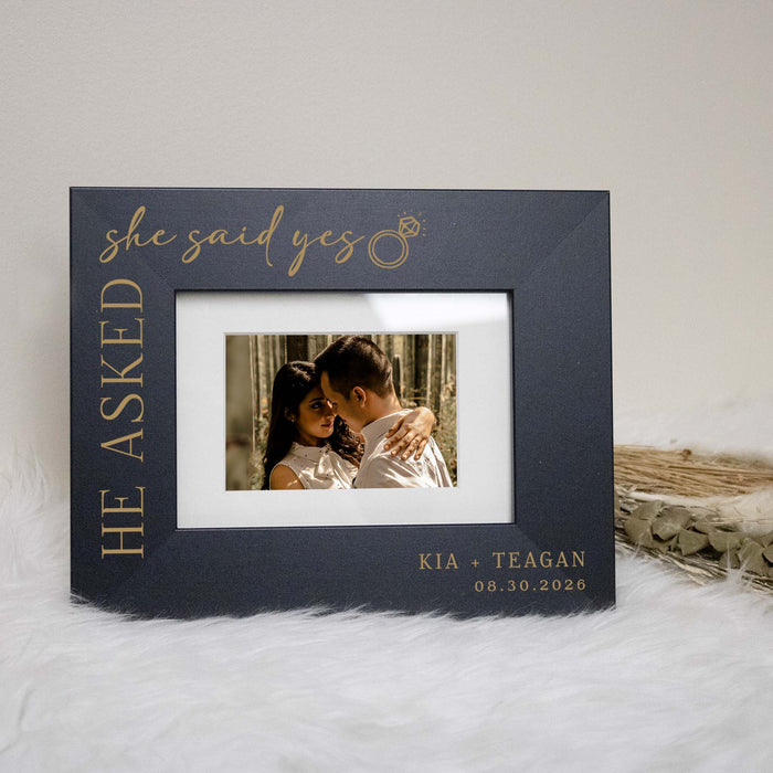 Personalized photo frame with 'he asked, she said yes' text, featuring a couple embracing.