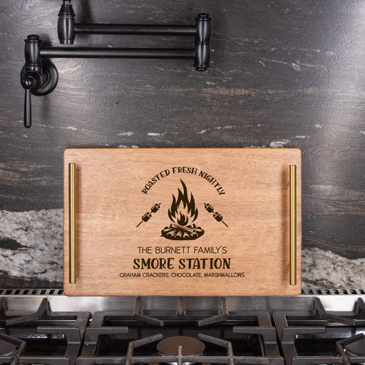 Wooden serving tray with a "S'more Station" design on a kitchen stove