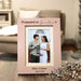 Light pink vertical photo frame that has "Promoted to Grandma" engraved in dark brown, photo inside showing a pregnant woman and man holding ultrasound pictures