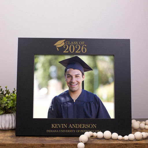 Graduation photo frame with 'Class of 2026' and a photo of a graduate inside, on a wooden surface.