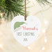 Heart-shaped ornament with 'Baby's First Christmas 2025' text, hanging on a Christmas tree.