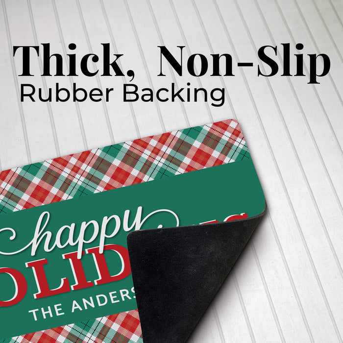 A holiday-themed doormat with a green front, red and green plaid pattern, and black rubber backing, shown on a white wood plank background with text reading 'Thick, Non-Slip Rubber Backing'.
