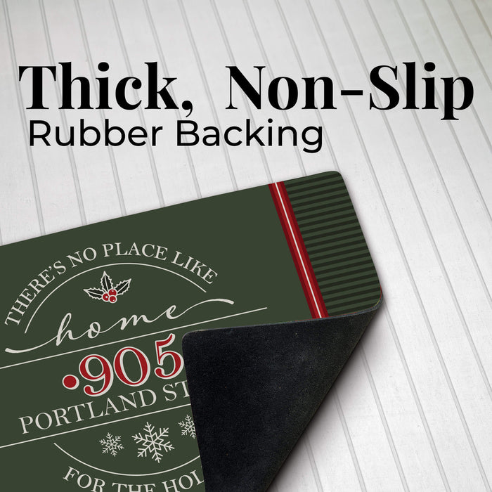 A dark green holiday-themed non-slip mat with a black textured underside, shown on a white paneled background with text reading 'Thick, Non-Slip Rubber Backing'. The mat features white and red text that reads 'There's no place like home for the Holidays'.