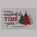 A rectangular gray holiday door mat with the phrase “IT’S THE MOST wonderful TIME OF the year” in black script and block lettering, decorated with three Christmas trees in green, red-and-black plaid, and black-and-white plaid. The bottom reads “THE SHEARER FAMILY.