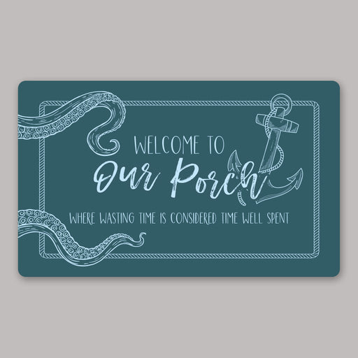 Teal nautical doormat with light blue text and anchor design on a gray background