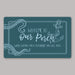 Teal nautical doormat with light blue text and anchor design on a gray background