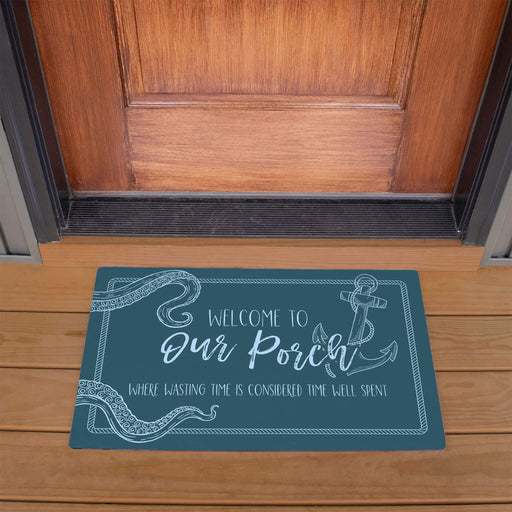 Doormat with 'Welcome to Our Porch' text on a wooden porch.