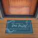Doormat with 'Welcome to Our Porch' text on a wooden porch.