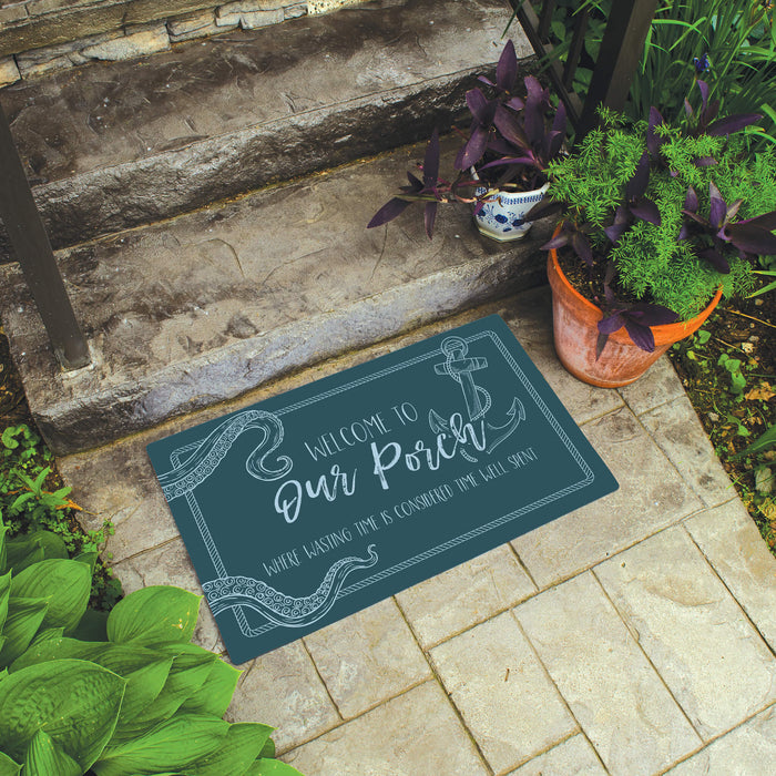 Decorative doormat with 'Welcome to Our Porch' text on a stone step with plants.