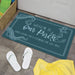 Doormat with 'Welcome to Our Porch' text on a floor with white sandals and a yellow towel.