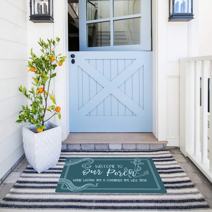 Front porch with a blue door, welcome mat, and potted plant.